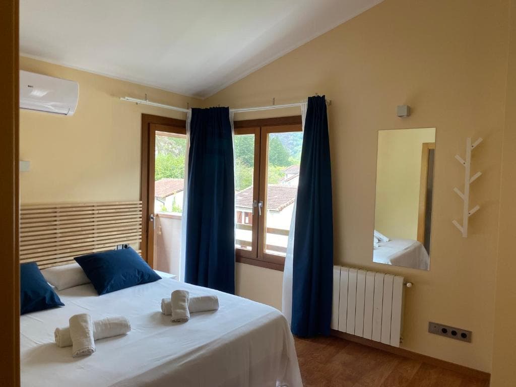 Dormitorio principal con cama de matrimonio, luz natural y vistas